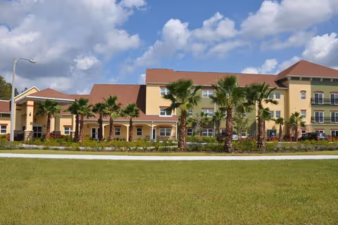 Exterior view of Angels Senior Living at Connerton Court with palm trees and a sunny sky
