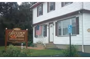 Exterior front view of Autumn Villa senior living facility with sign, flag, and accessible entry.
