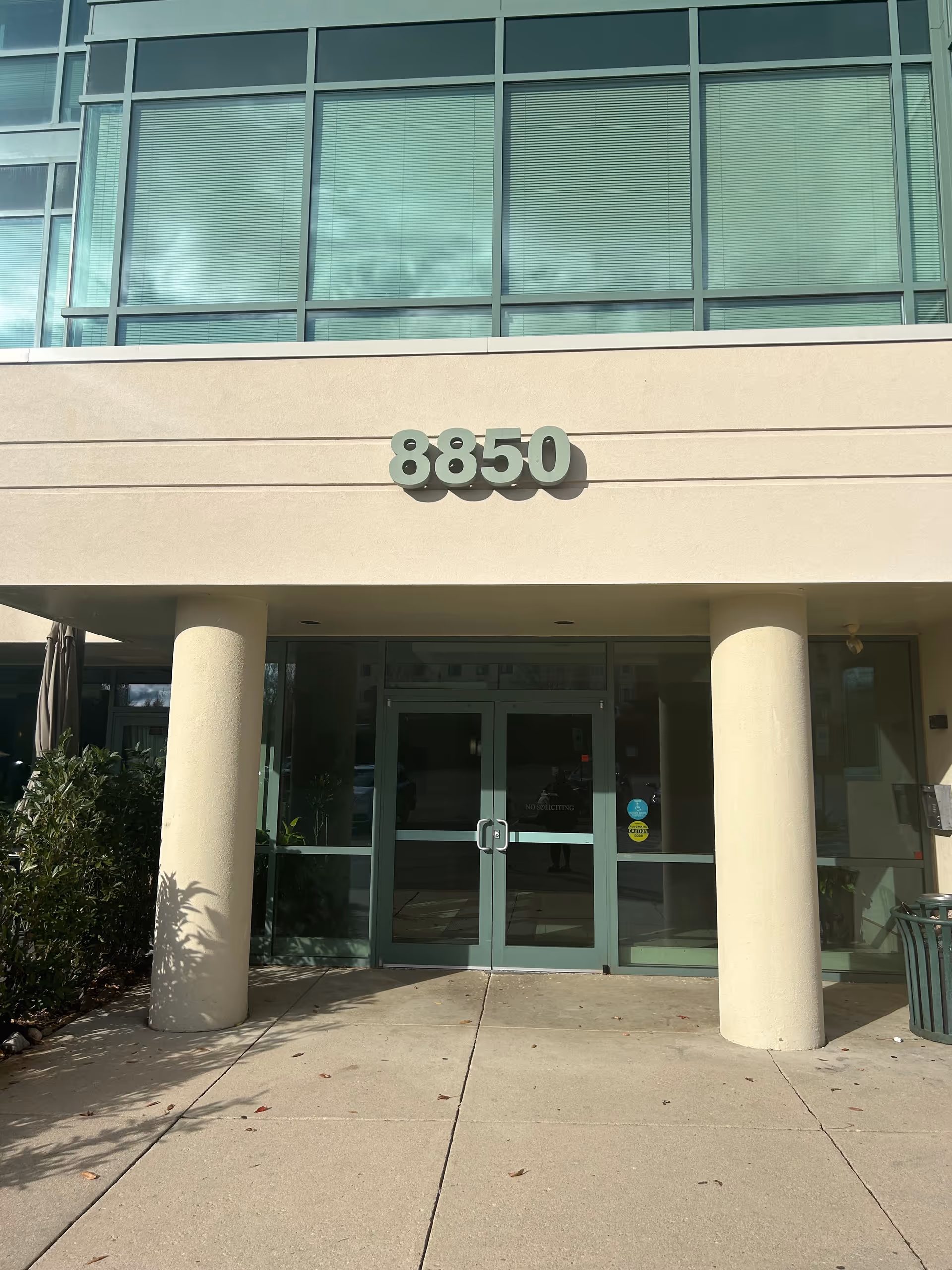 Exterior entrance of a modern building with large 8850 numbers over the doors.