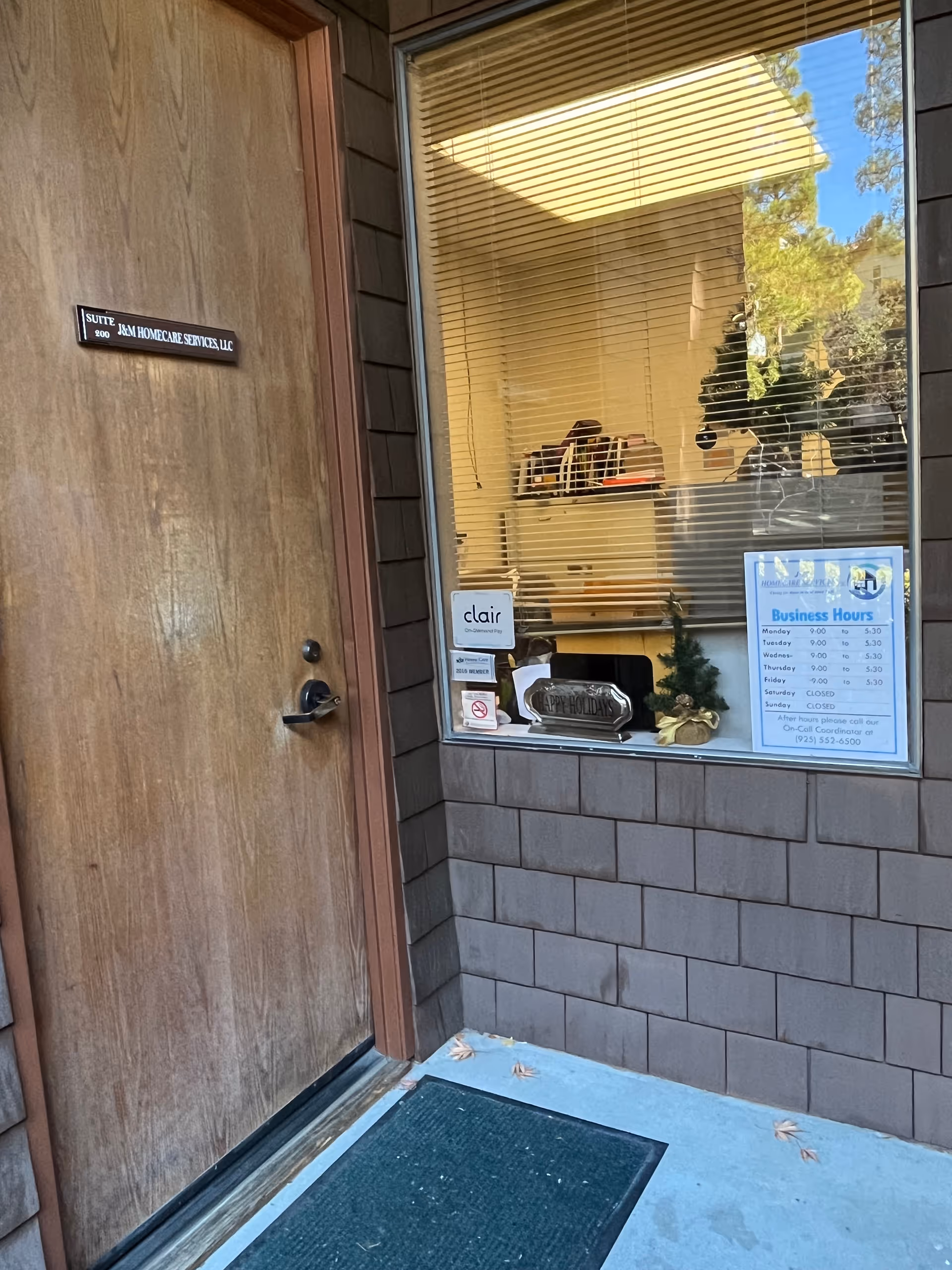 Exterior building entrance featuring a wooden door and window signs.