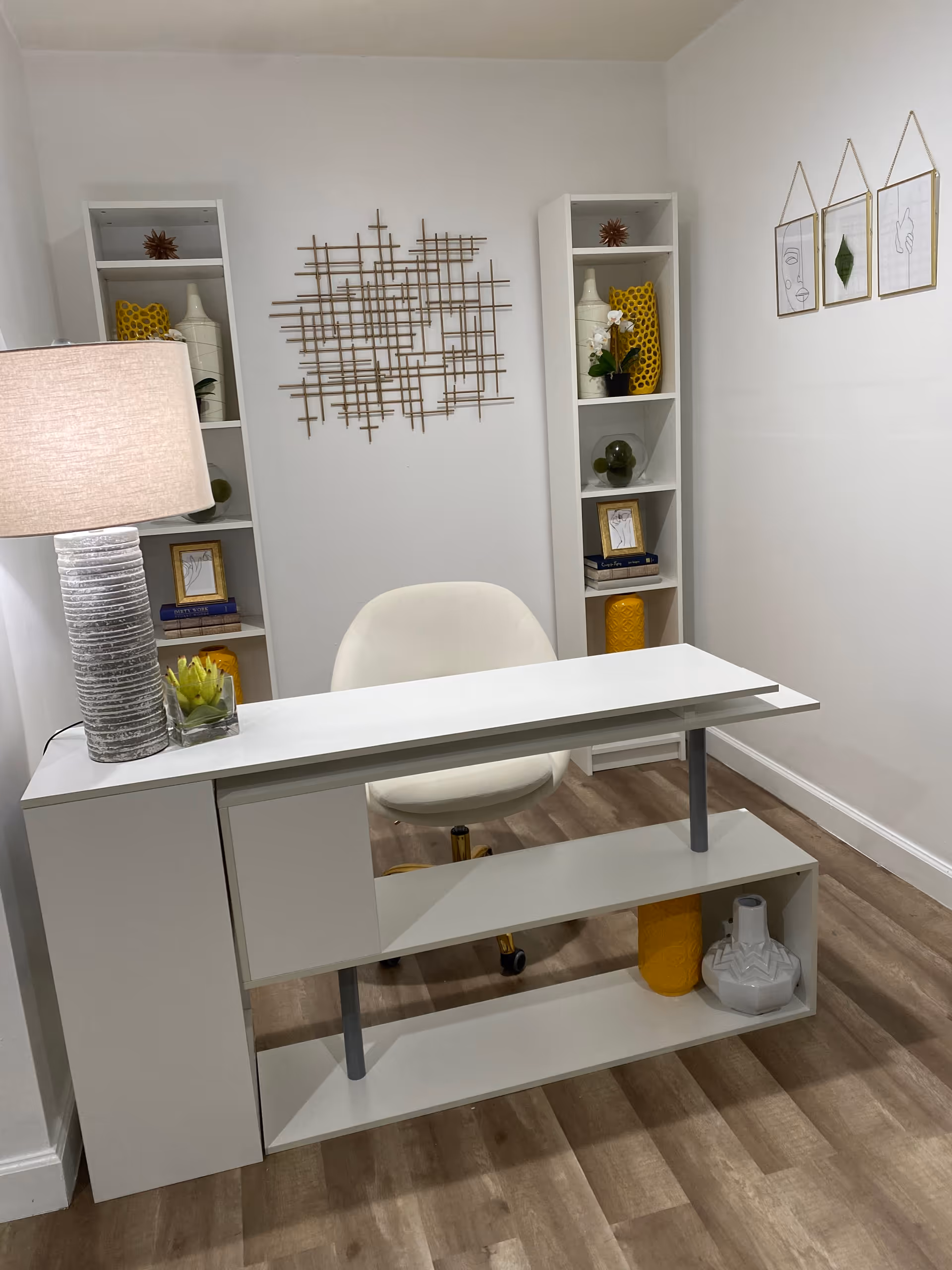 Modern white reception desk with shelves and decorative accents in a small office.