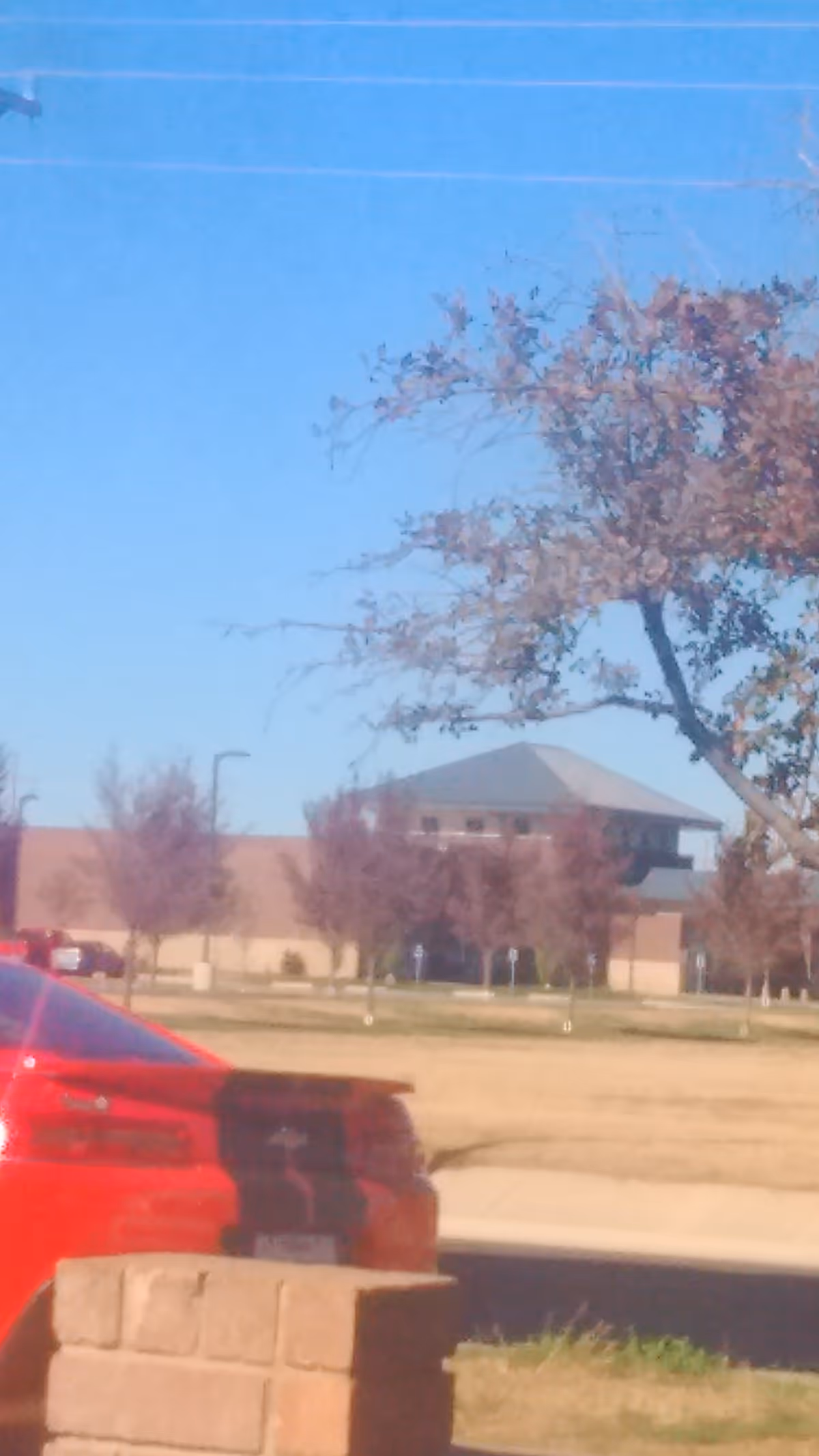 Exterior view of Hereford Regional Medical Center with a red car and trees.