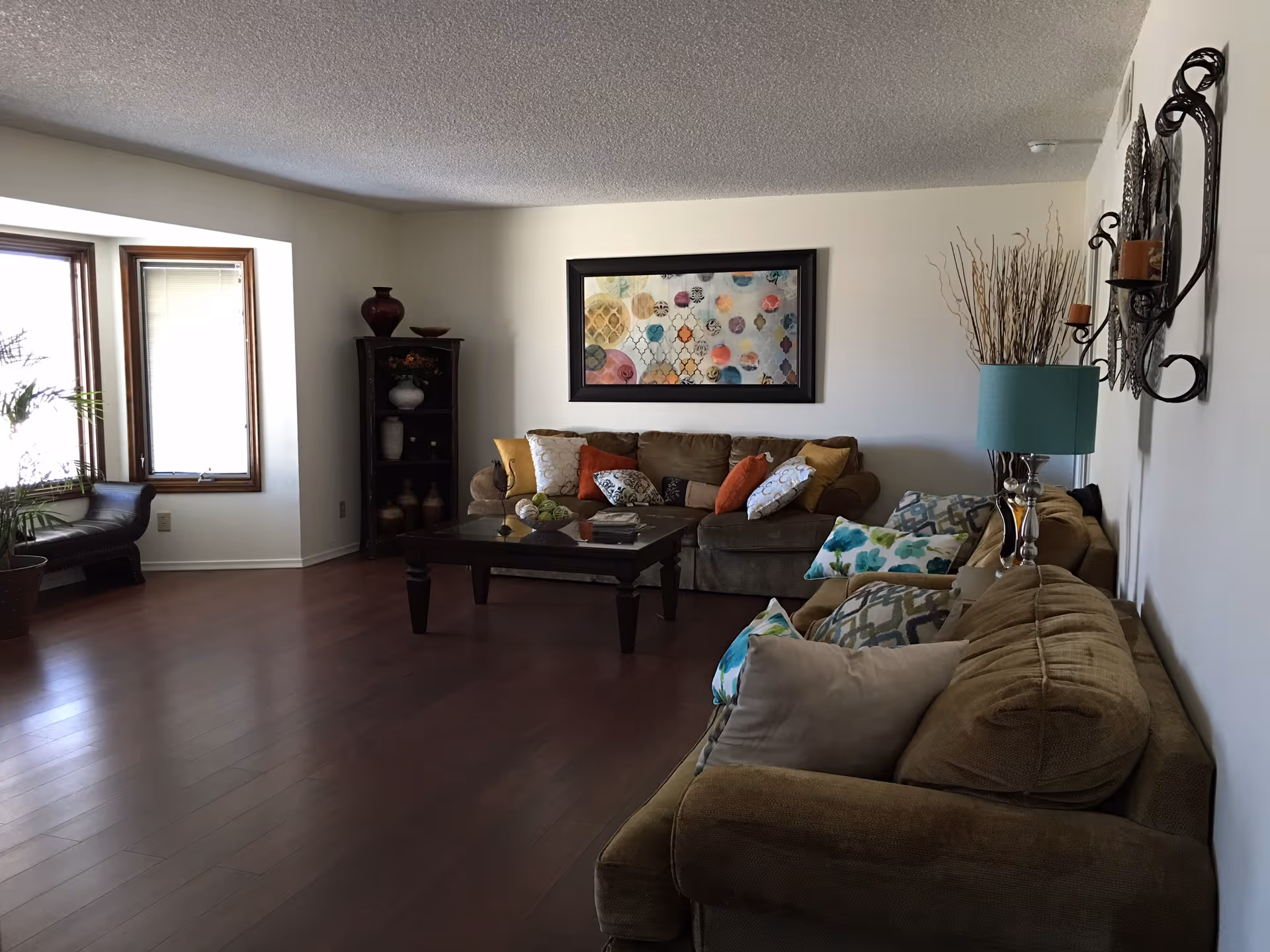 Spacious living room with brown sectional sofa, coffee table, and wall art.