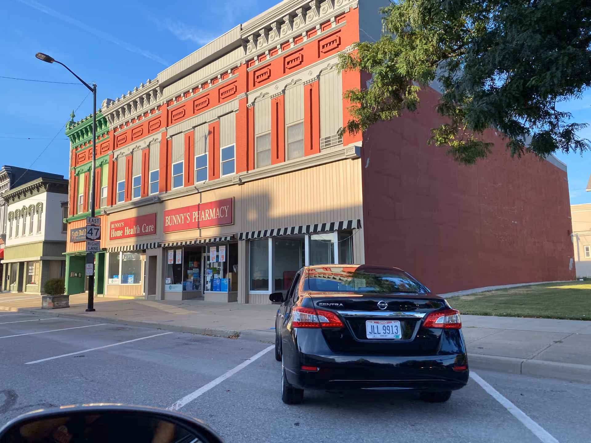 Street view of a red-brick building with Bunny's Home Health Care storefronts and a parked car.