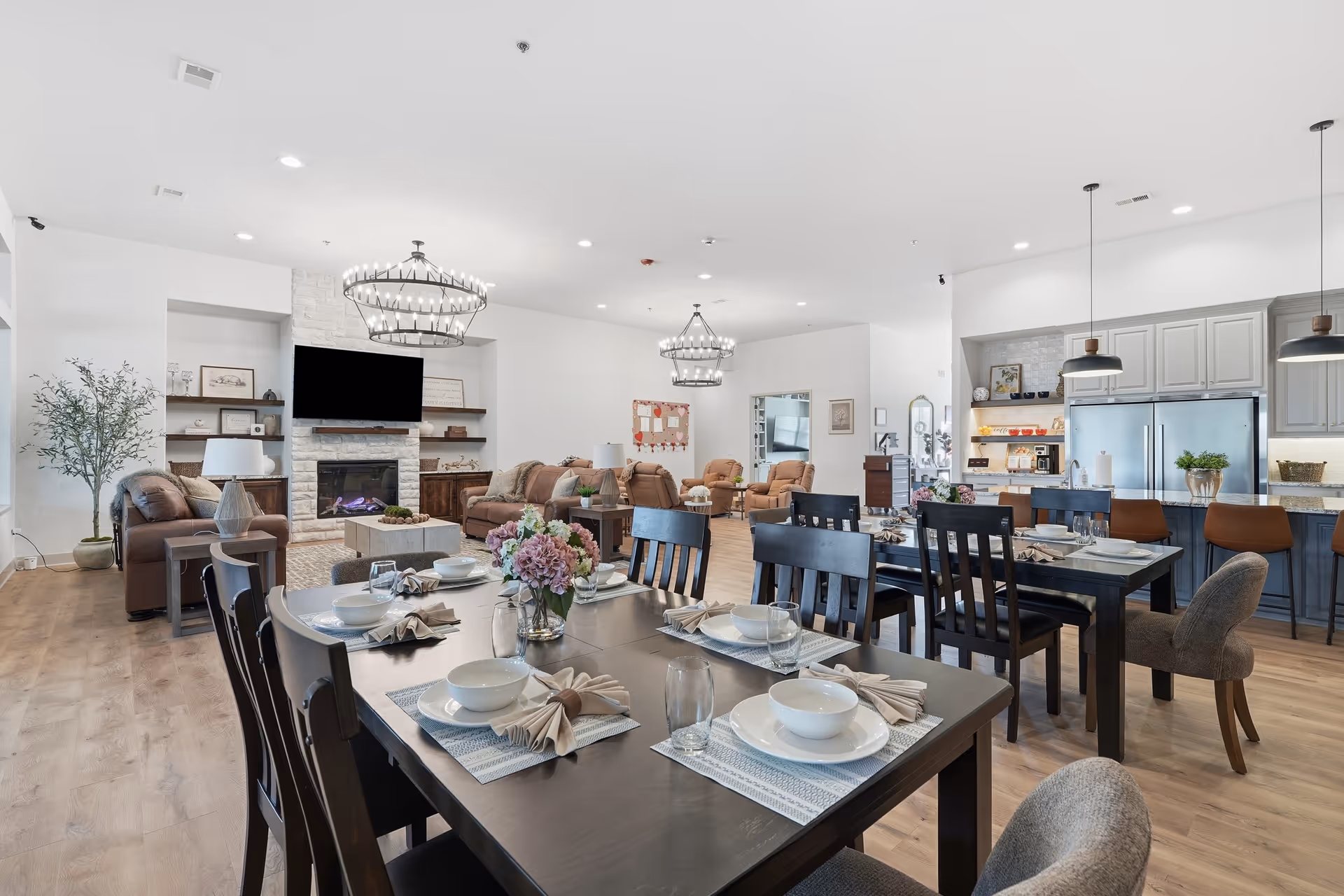 Open-plan senior living space with dining tables, living area seating, and a modern kitchen.