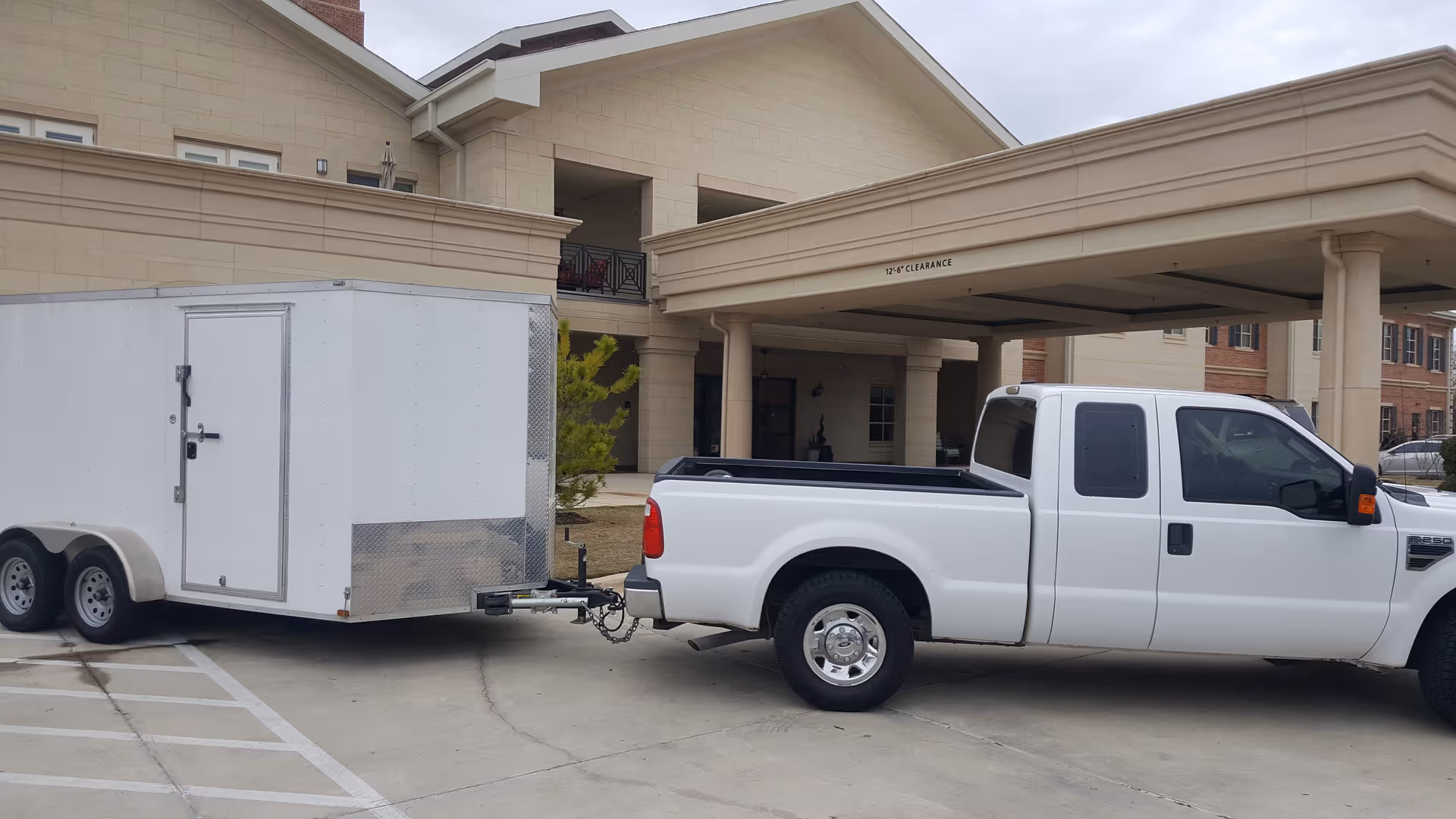 Exterior view of HarborChase of Southlake entrance with a white pickup towing a trailer.