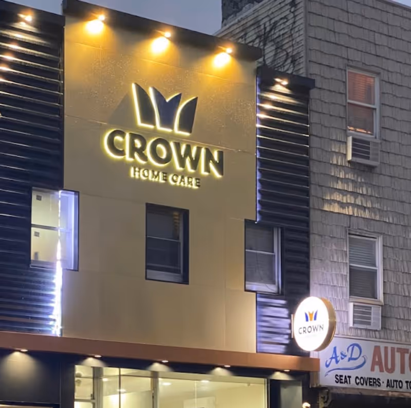 Exterior view of a building front with an illuminated Crown Home Care sign.