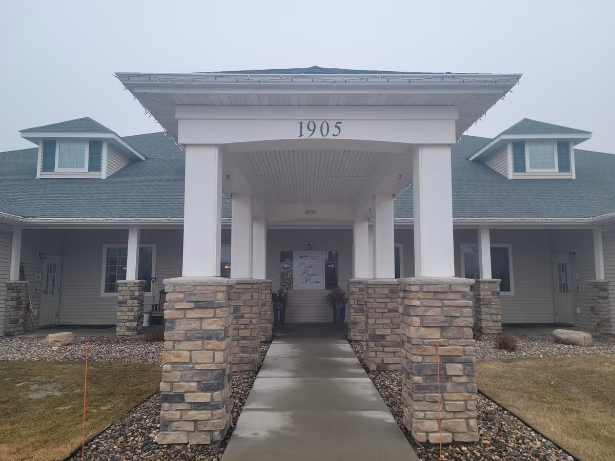 Front entrance of Birchwood Cottage II with a covered walkway and stone pillars.