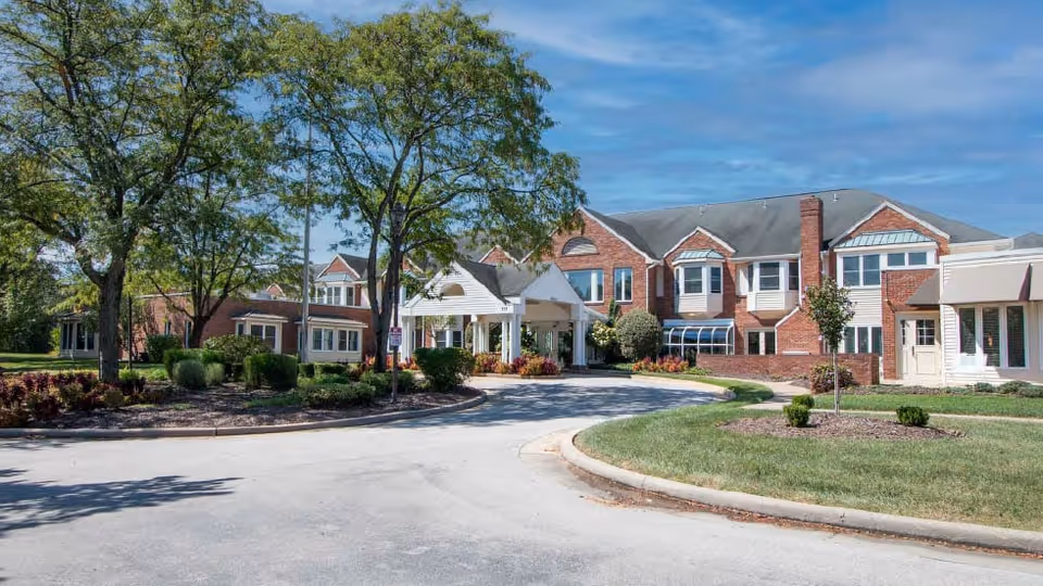 Brick senior living facility with entrance canopy and landscaped front grounds.
