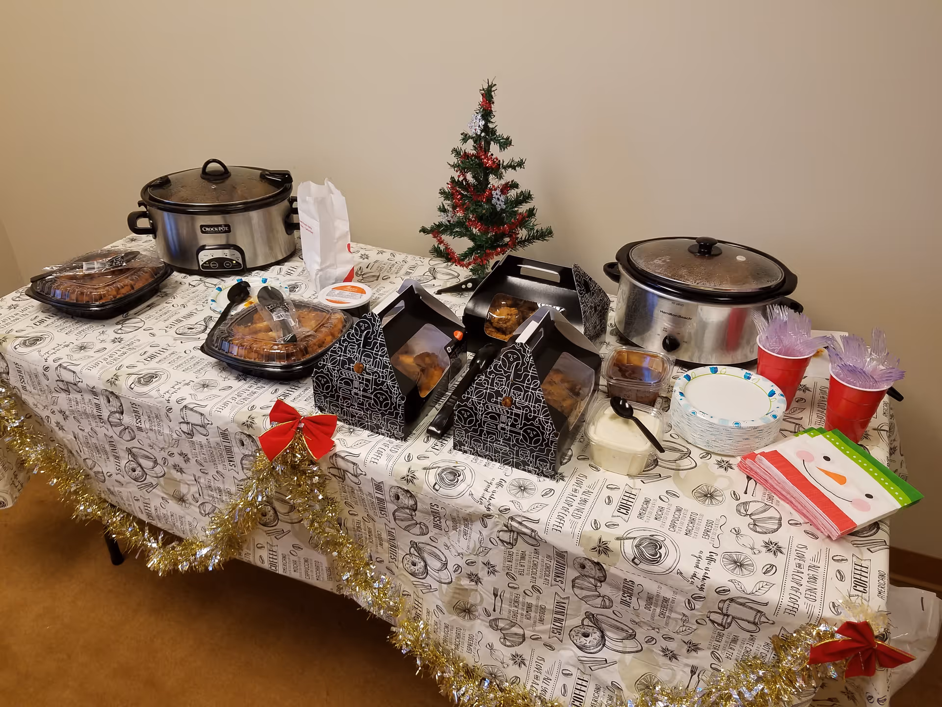 Festive catering display on a decorated dining table with a small Christmas tree.