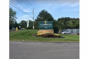 Exterior view of Elderwood at Liverpool sign on a grassy median by a road