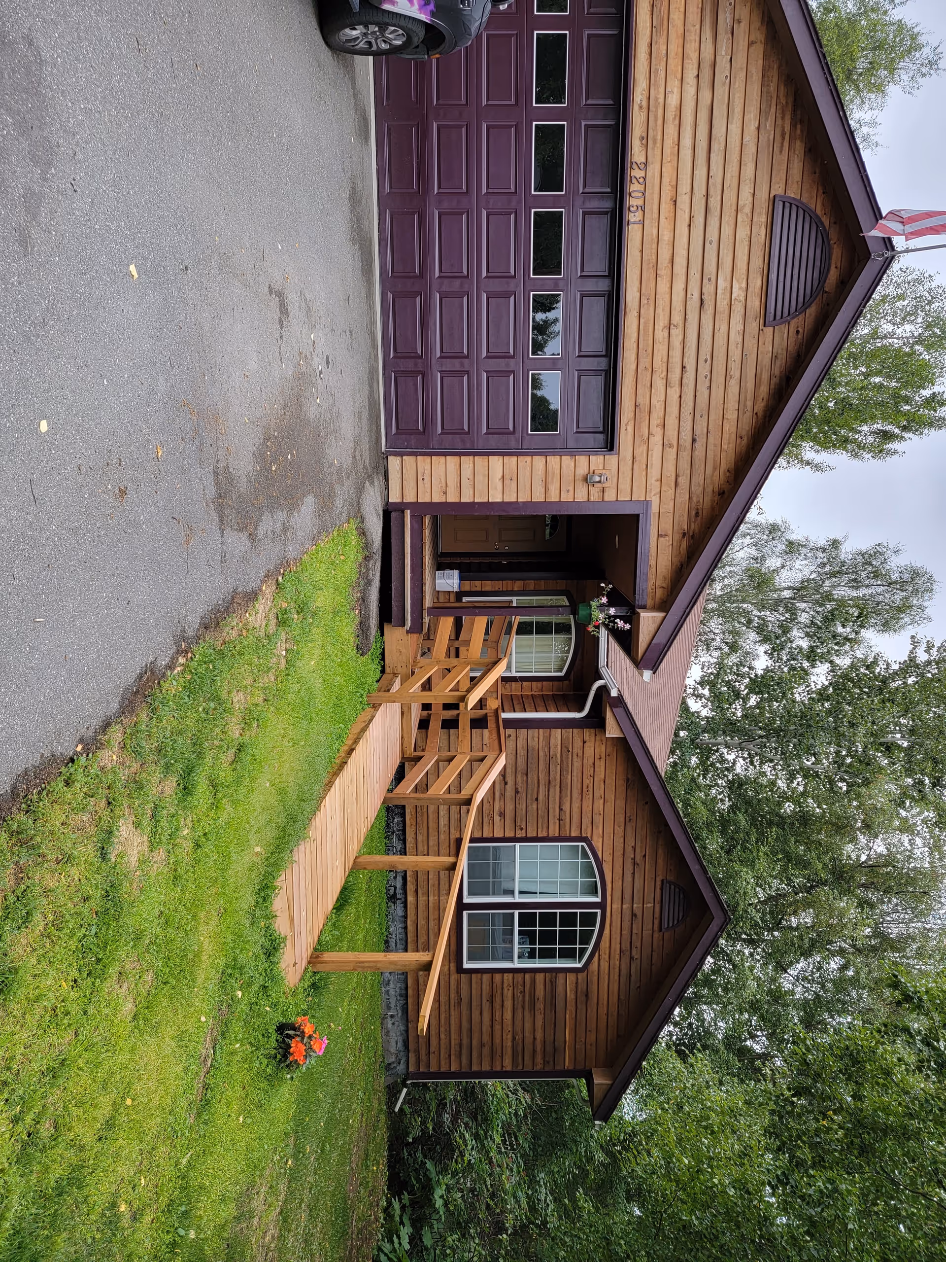 Exterior of Everly House senior living facility with wooden siding, ramp, and green lawn.