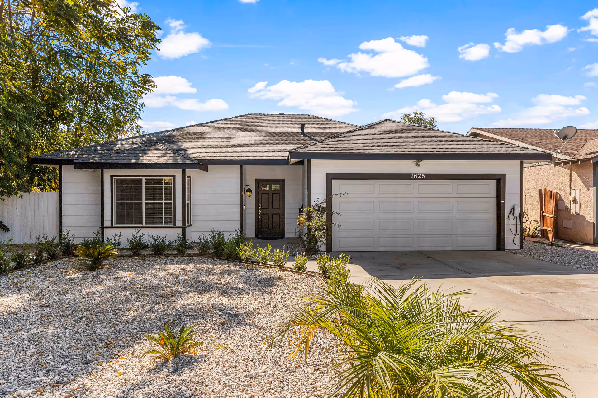 Front view of a single-story house with a two-car garage and desert landscaping.