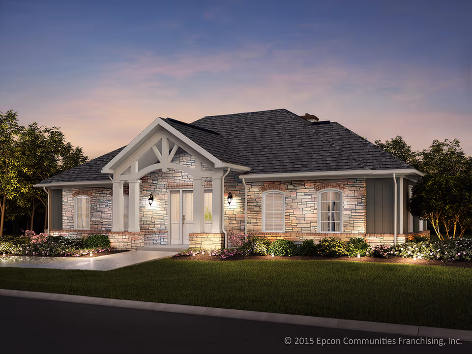 Stone-and-brick senior living building with front porch and landscaped yard at dusk.