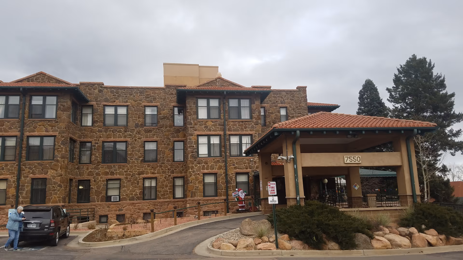 Stone-clad Mount St Francis Nursing Center exterior with covered entrance and parking lot.