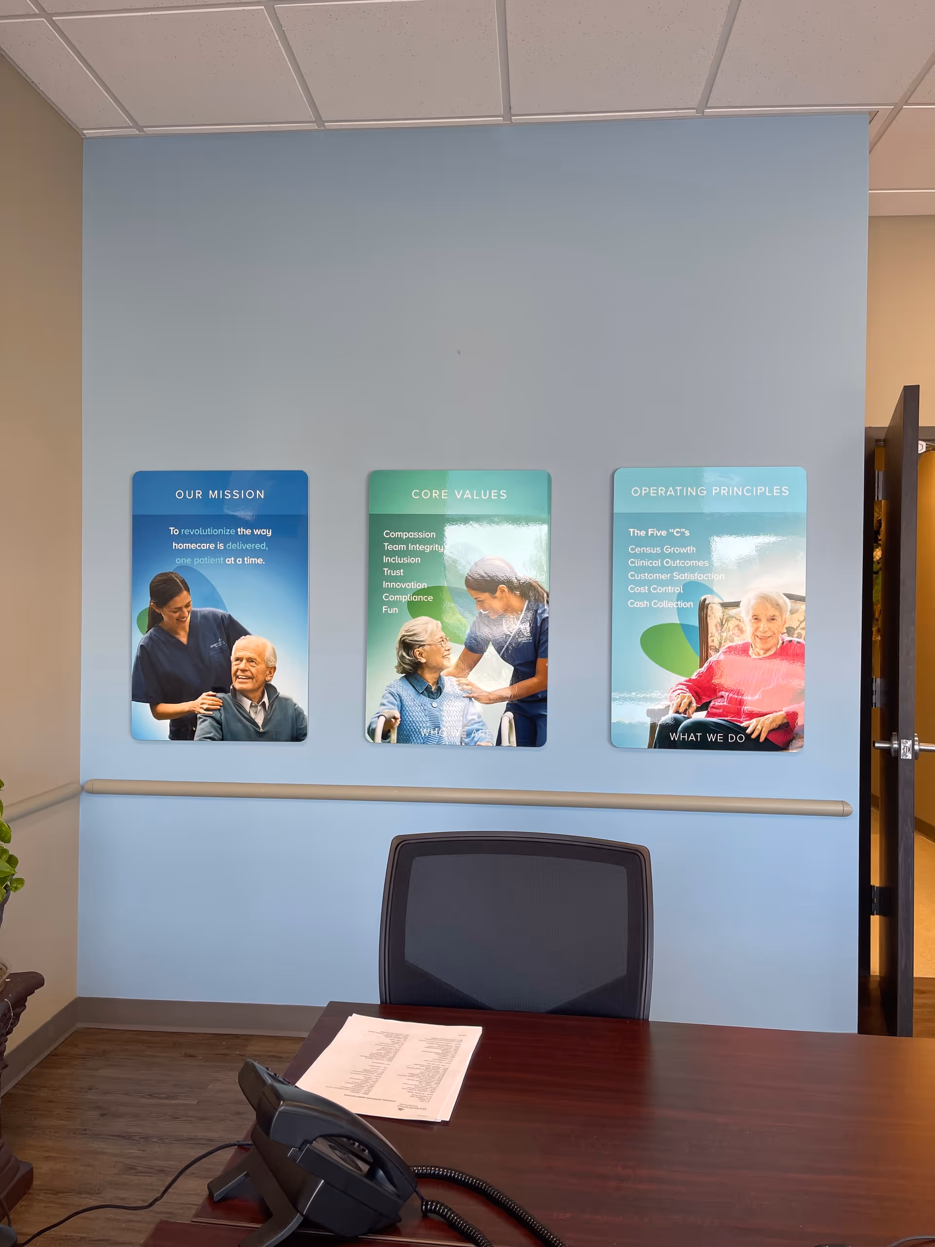 Aveanna Hospice reception area with desk, chair, and wall posters.