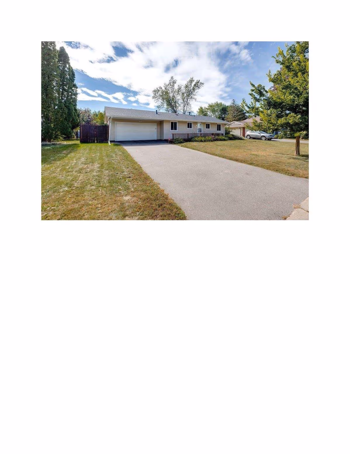 Single-story facility with a long driveway, attached garage, and surrounding lawn.