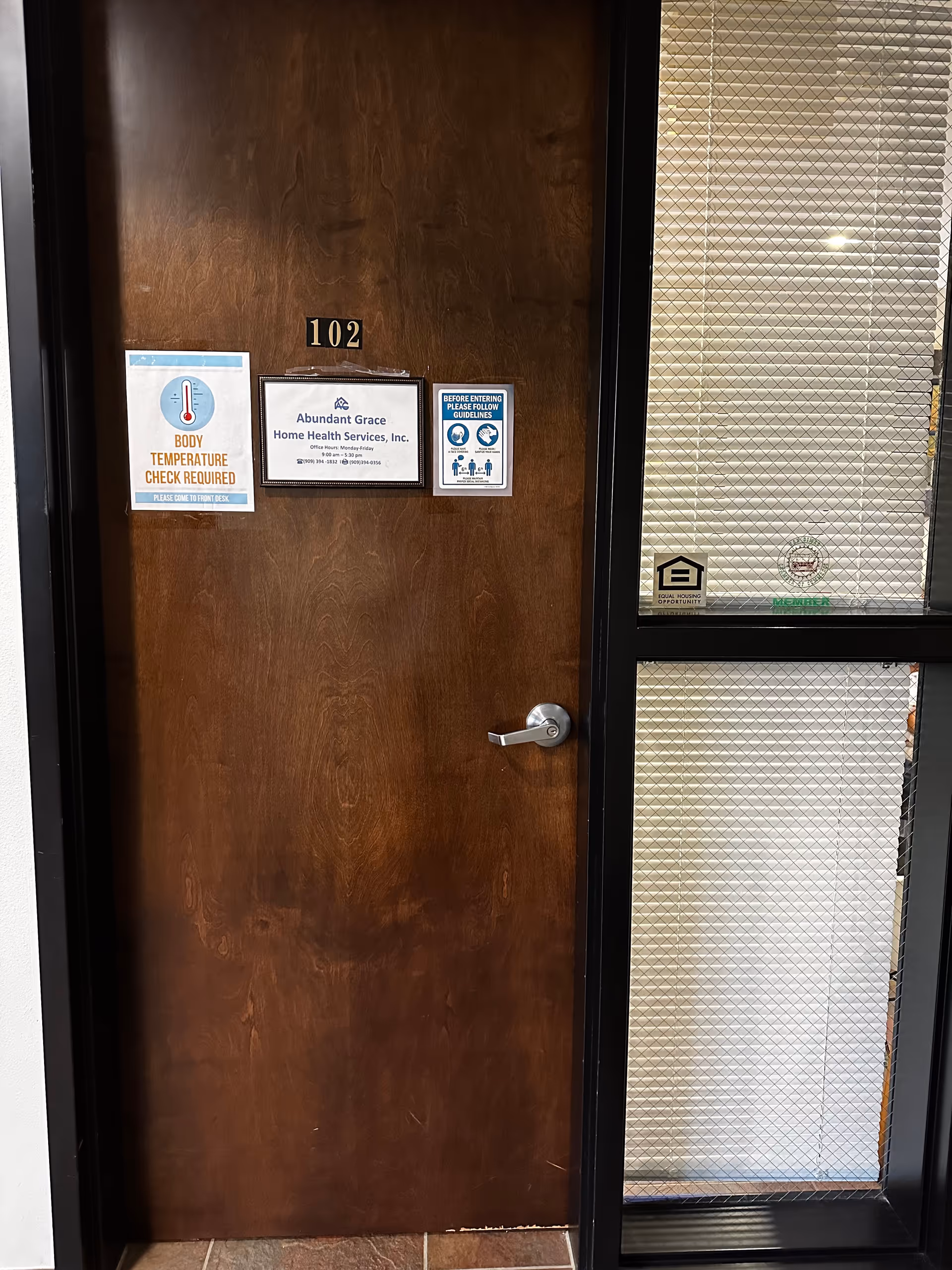 A wooden door labeled 102 with Abundant Grace Home Health Services signs.