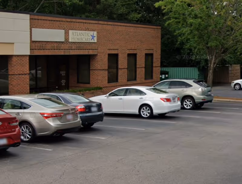 Exterior view of Atlantic Homecare Services building with several cars parked outside.