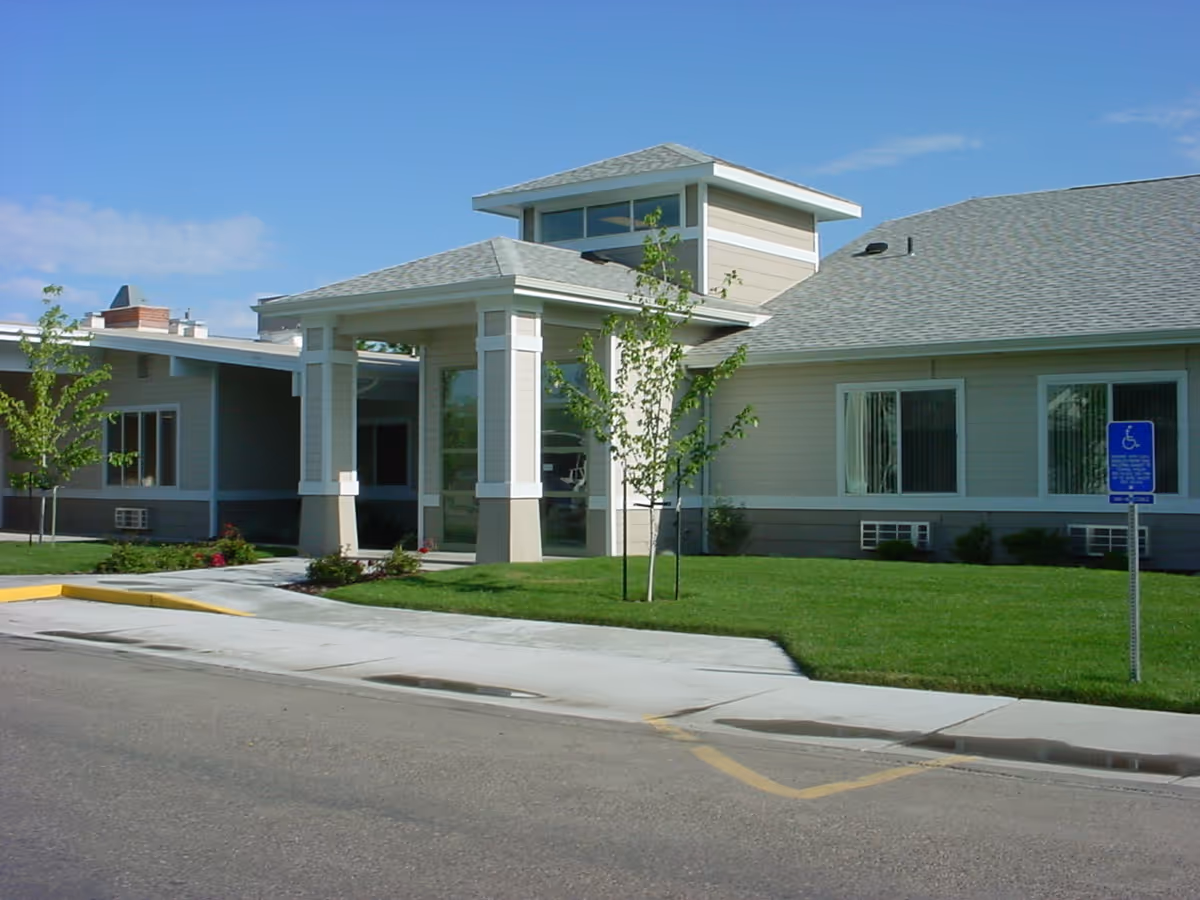 Exterior view of Pioneer Place Assisted Living building with entrance and wheelchair sign.