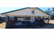 Single-story Oaks Nursing Center building with a front porch and star emblem.