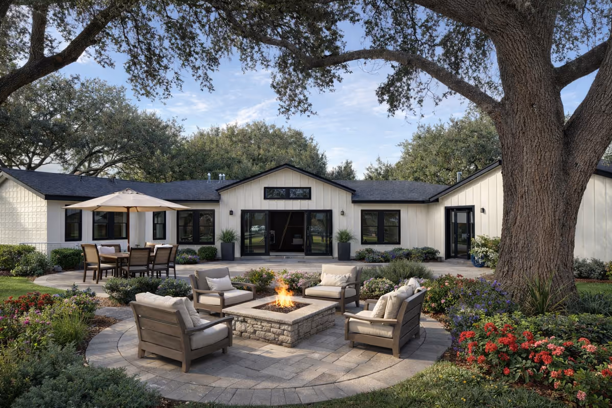 Outdoor courtyard with a stone fire pit, seating, and a building in the background.