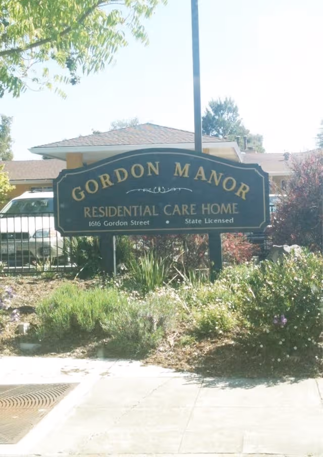 Gordon Manor sign outside a residential care home with landscaping and sidewalk.