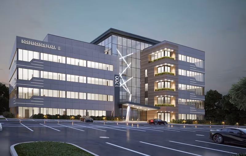 Modern multi-story facility exterior with glass walls and a spacious parking lot.