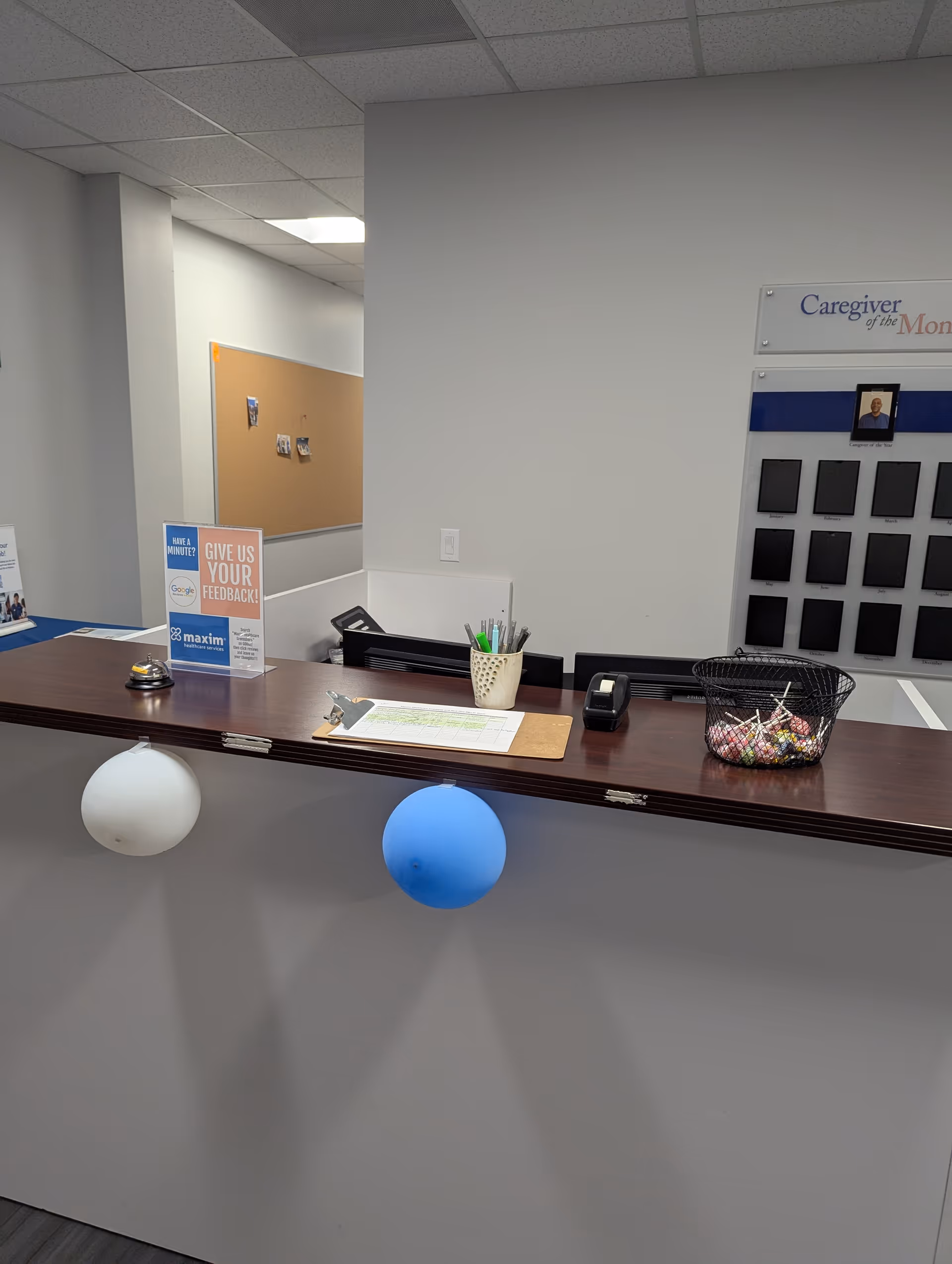 Interior reception desk area with balloons and desk supplies.