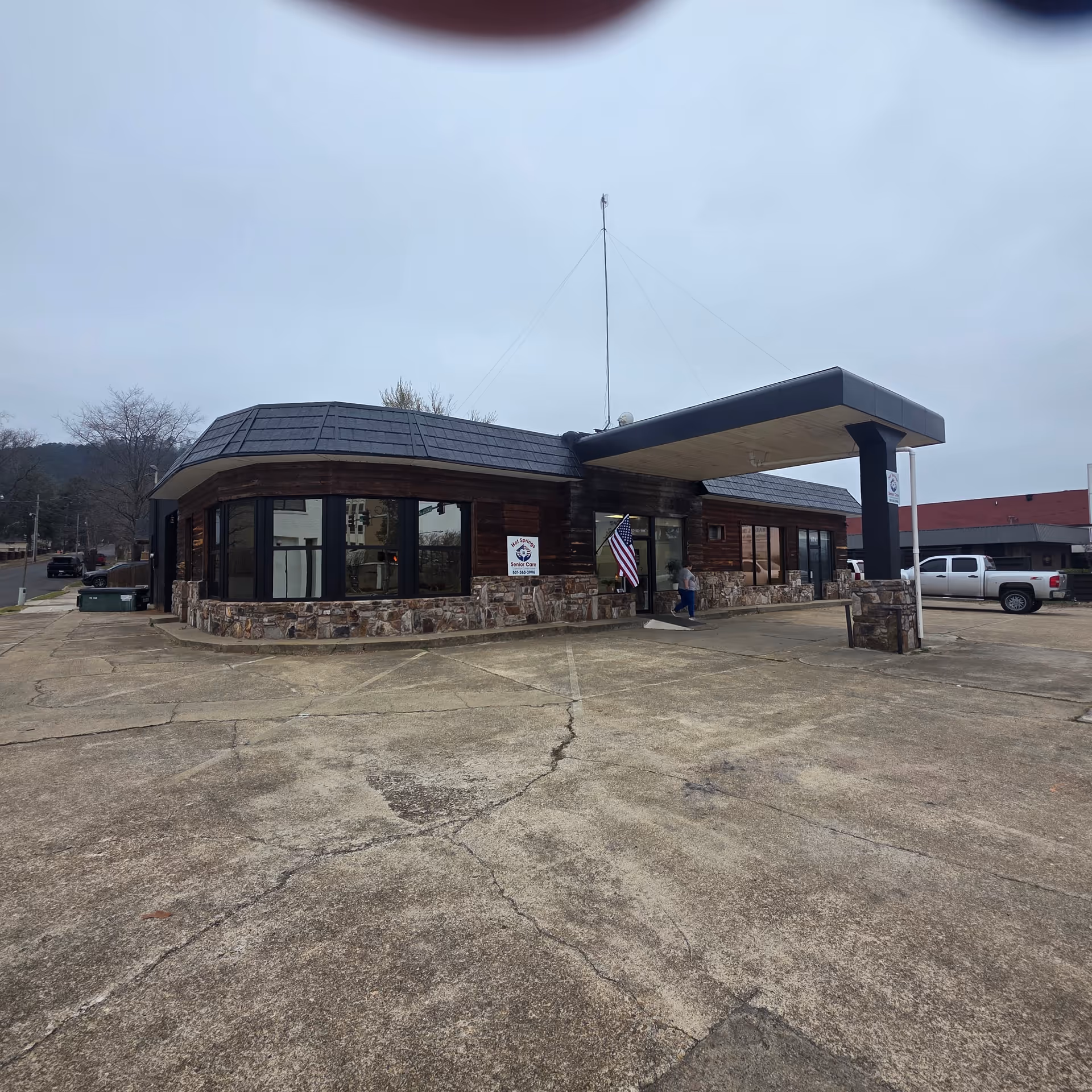 Exterior view of HOT SPRINGS SENIOR CARE building with stone base and canopy entrance.