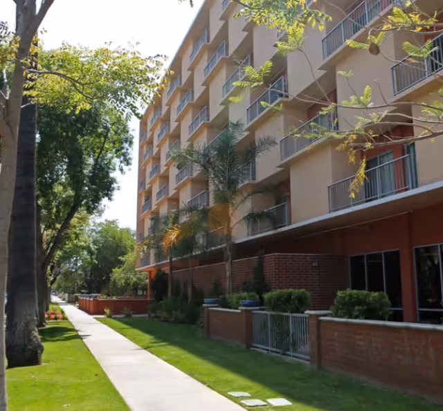 Sunflower Meadows #2 exterior view of a multi-story senior living building with a sidewalk.