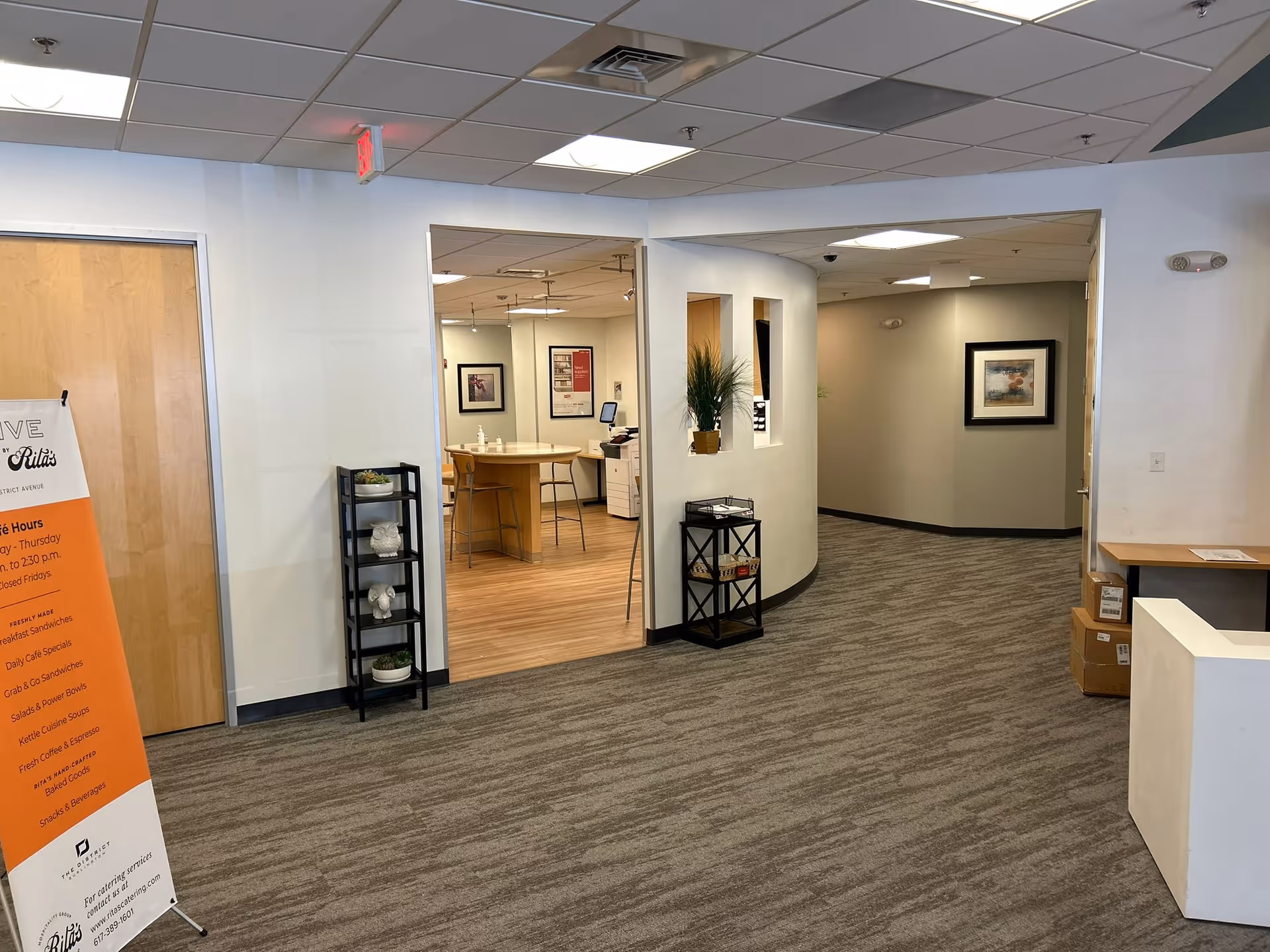Lobby area with curved wall, seating, plants, artwork, and reception desk.