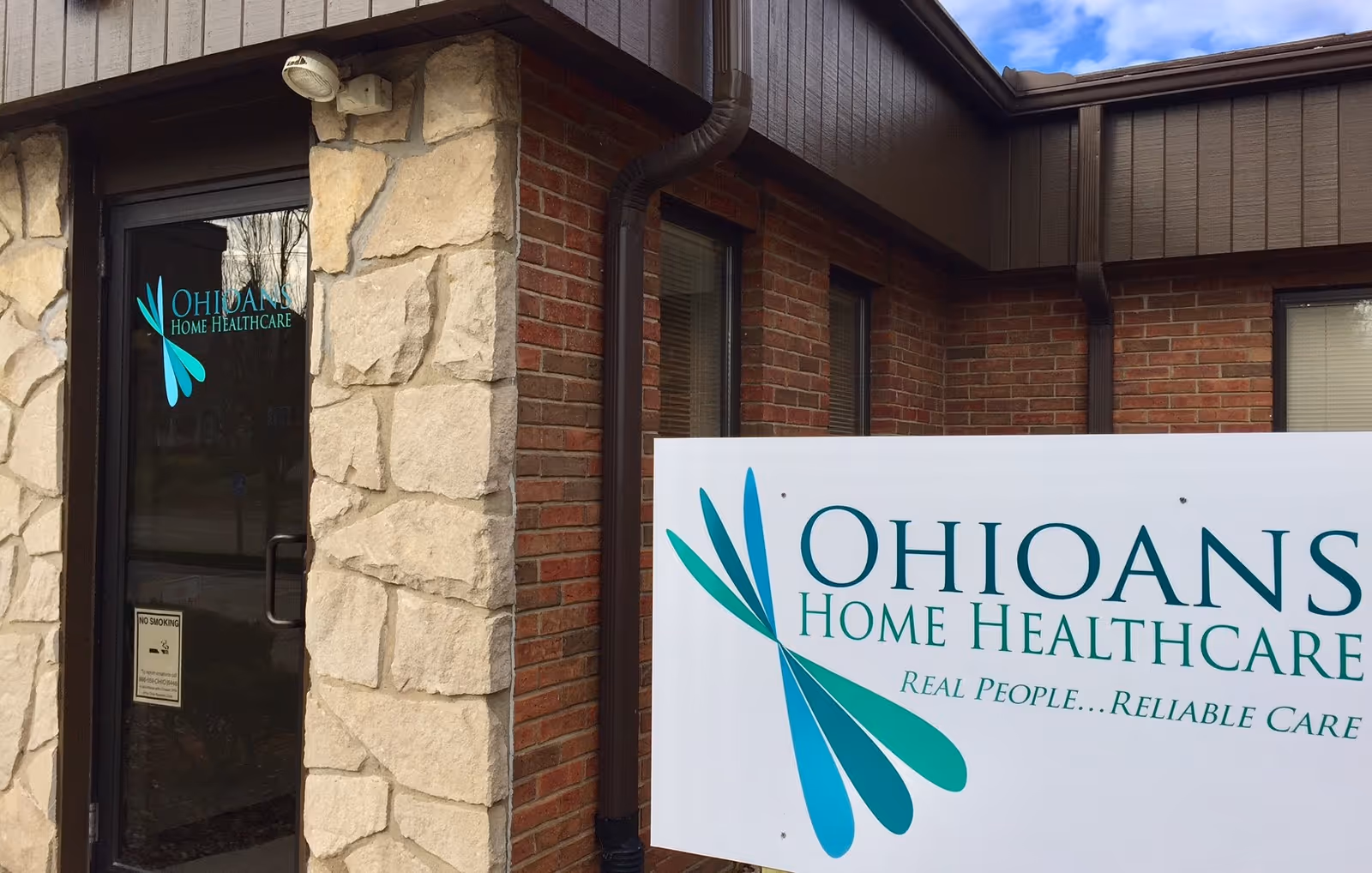 Exterior view of Ohioans Home Healthcare facility with brick walls, stone column, and a large sign.