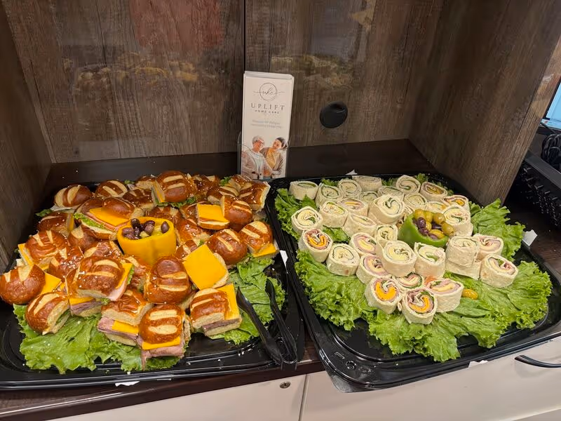 Assorted sandwiches and wraps displayed on lettuce on a countertop.