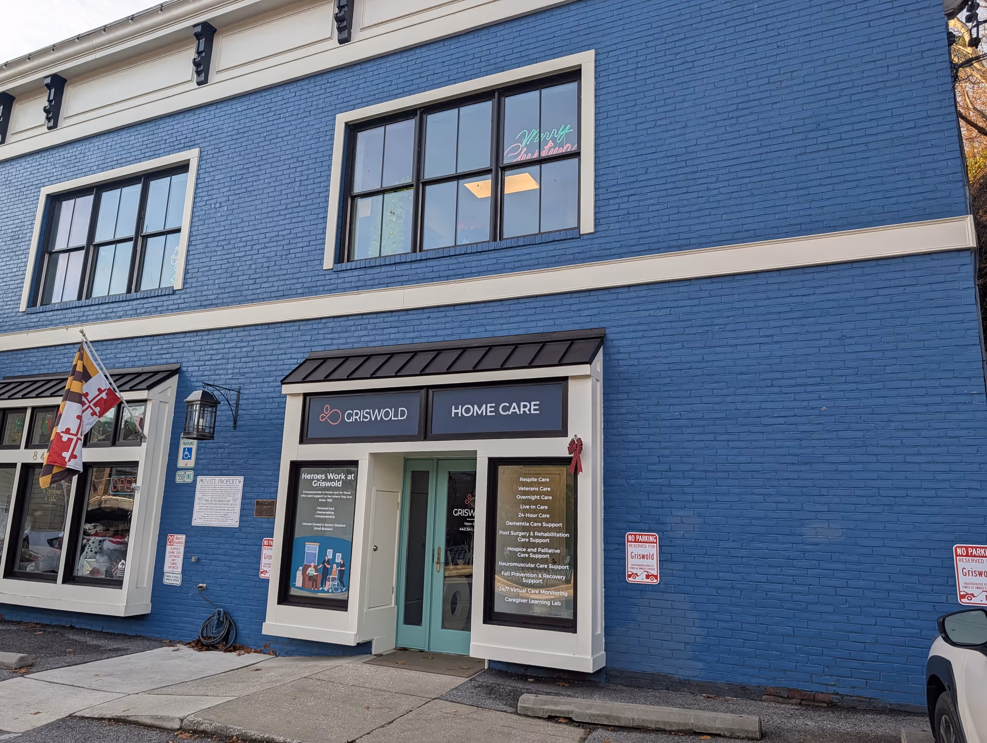 Blue brick building facade with Griswold Home Care entrance and large windows.