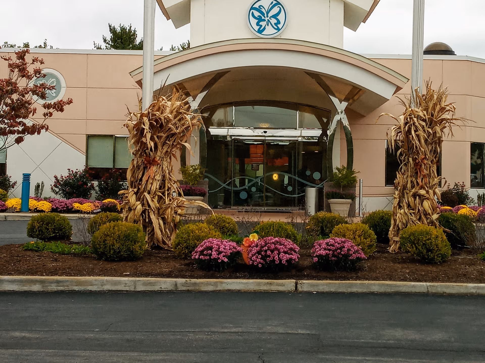 Front entrance of Delmar Gardens South with glass doors and curved arch.