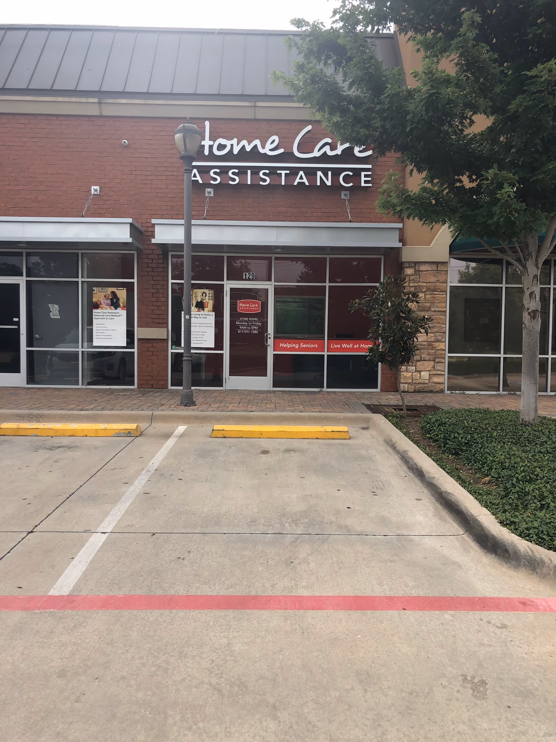 Storefront of Home Care Assistance Arlington with glass doors and parking lot in foreground.