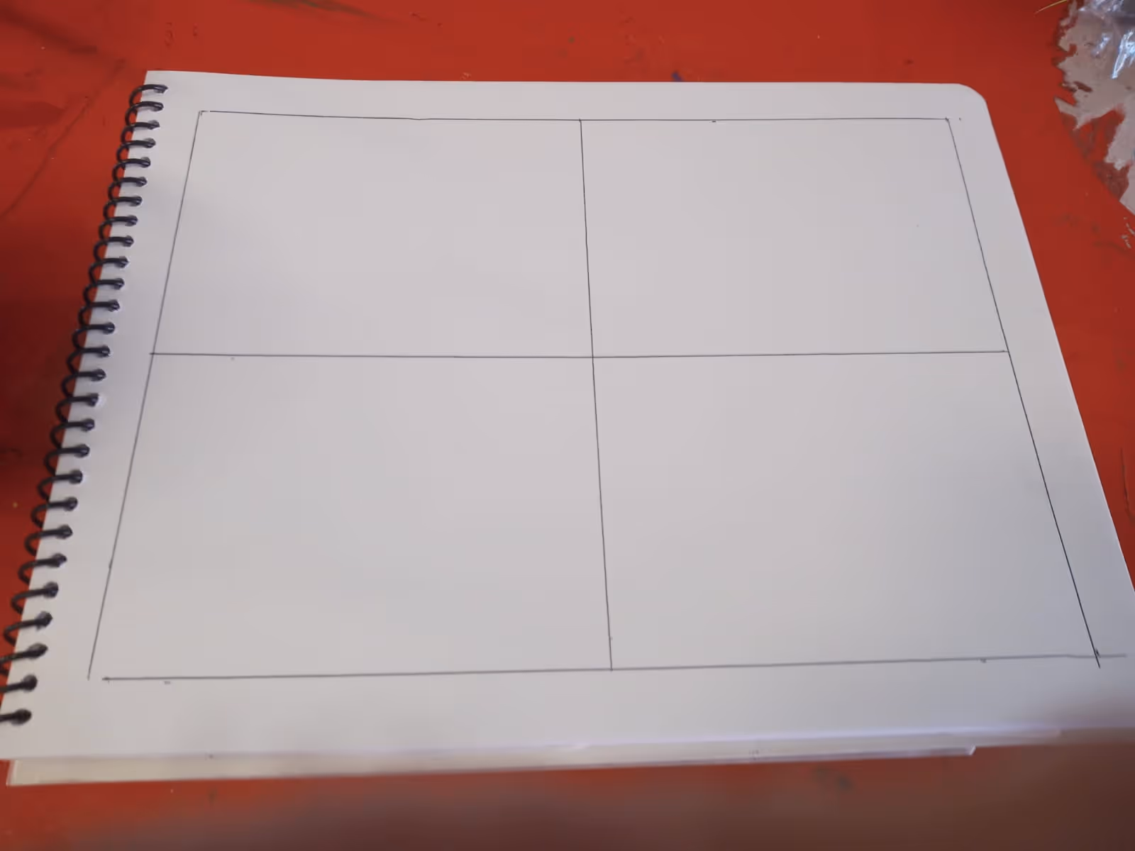 Notebook page with a four-panel floor plan sketch on a red table.