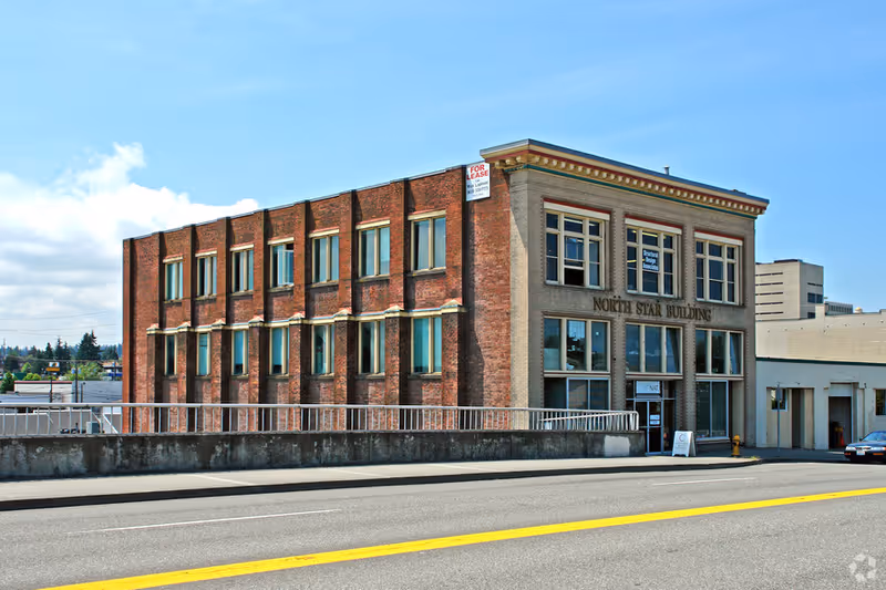 Brick two-story North Star Building with large windows along street.