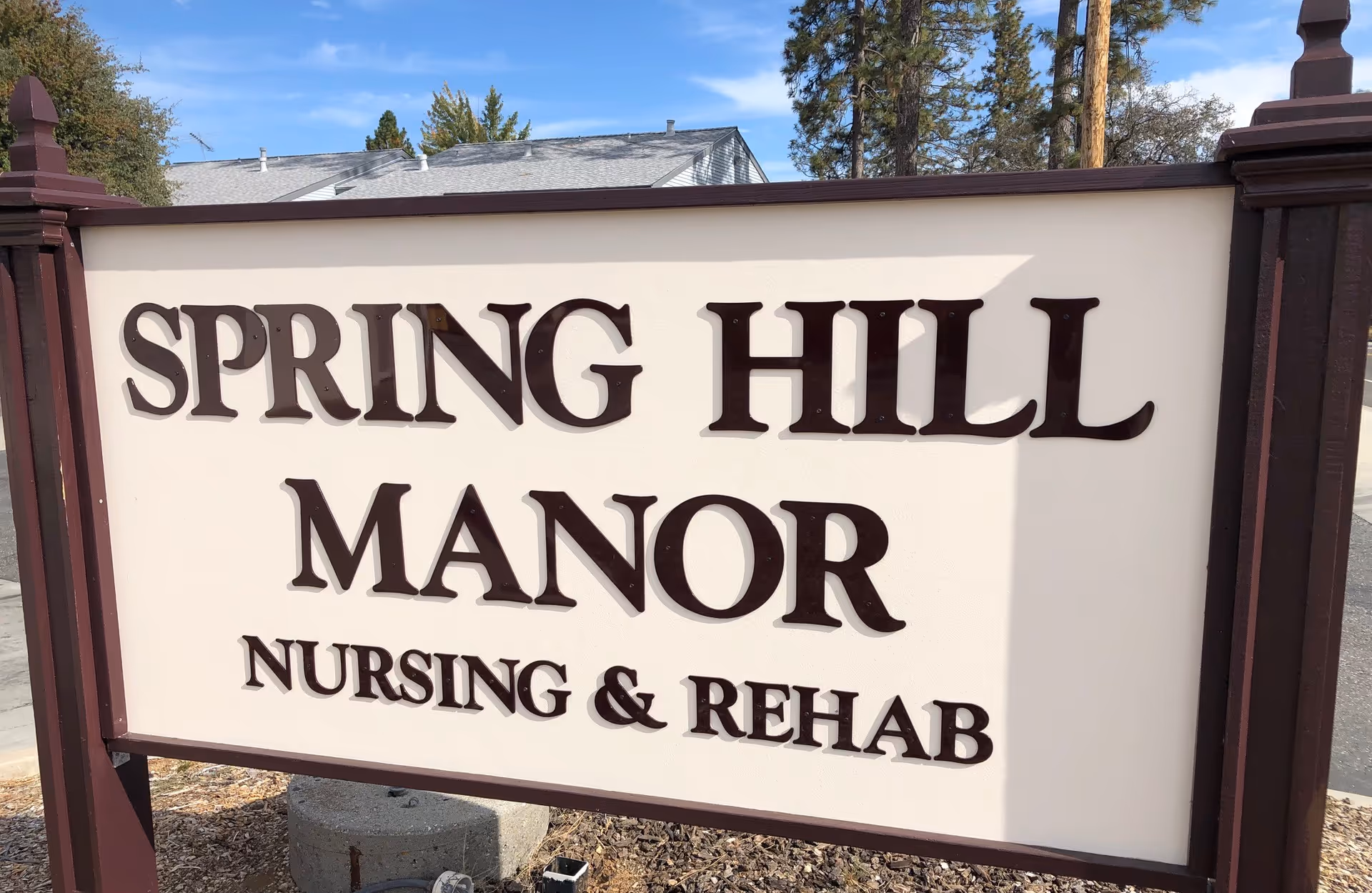 A large front sign reads Spring Hill Manor Nursing and Rehab beside a building.