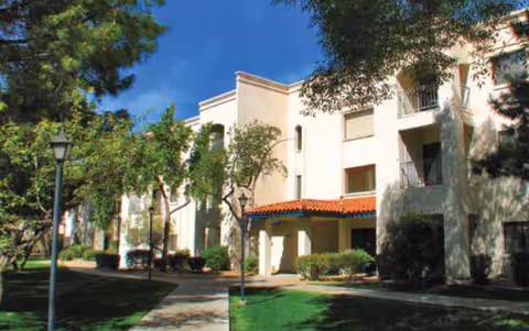 Exterior view of Fellowship Square Phoenix building with a courtyard and trees.