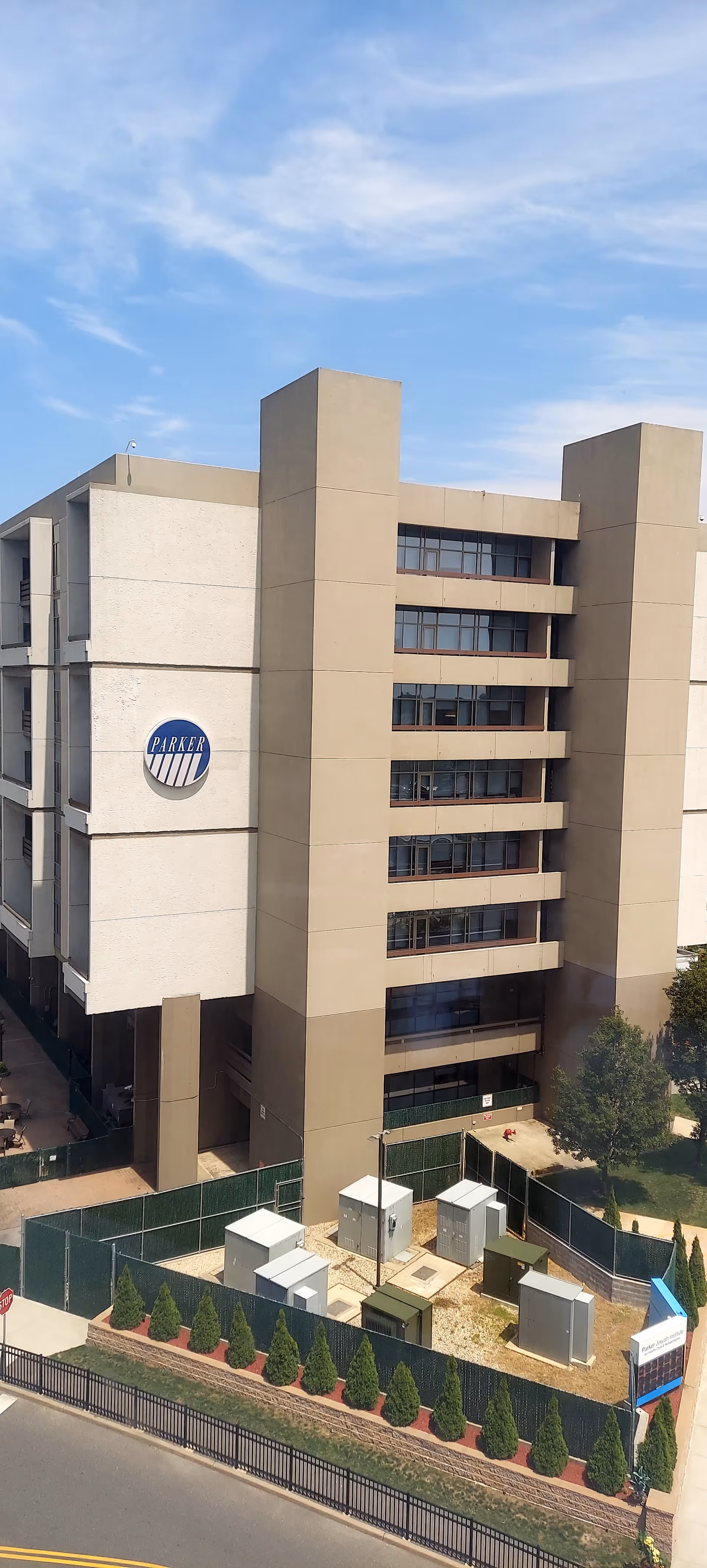 Tall beige Parker Jewish Institute building with a circular logo, visible from the street.
