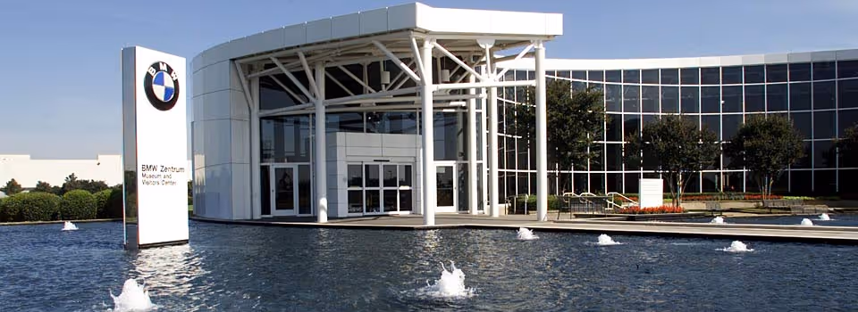 Front view of a modern glass building with water features and a large entrance.