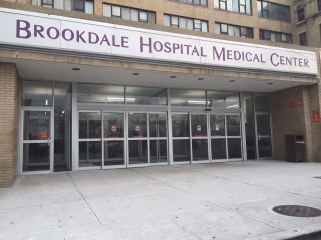 Front entrance of Brookdale Hospital Medical Center with glass doors and signage.