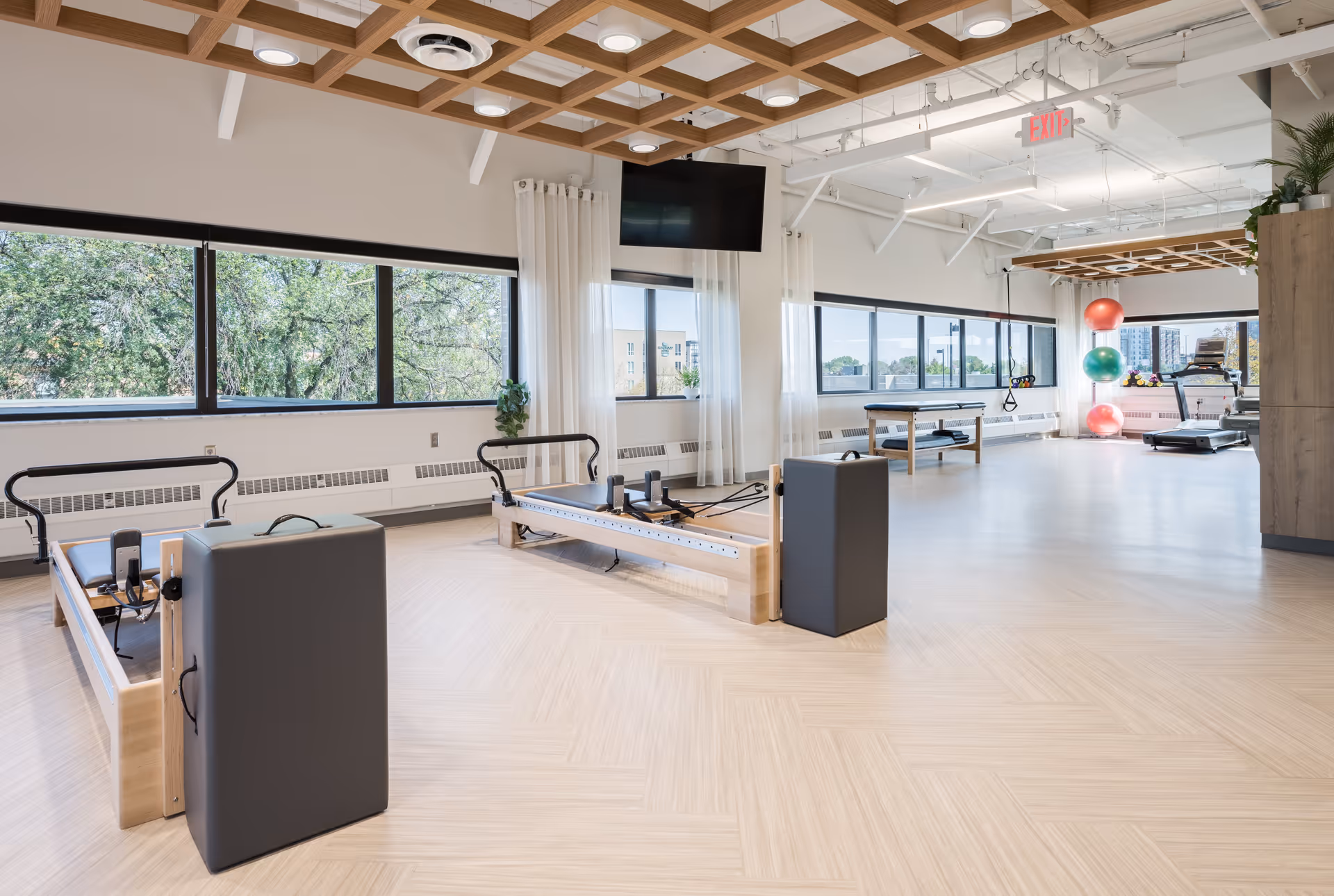 Open, well-lit senior fitness room with Pilates reformers and exercise equipment.