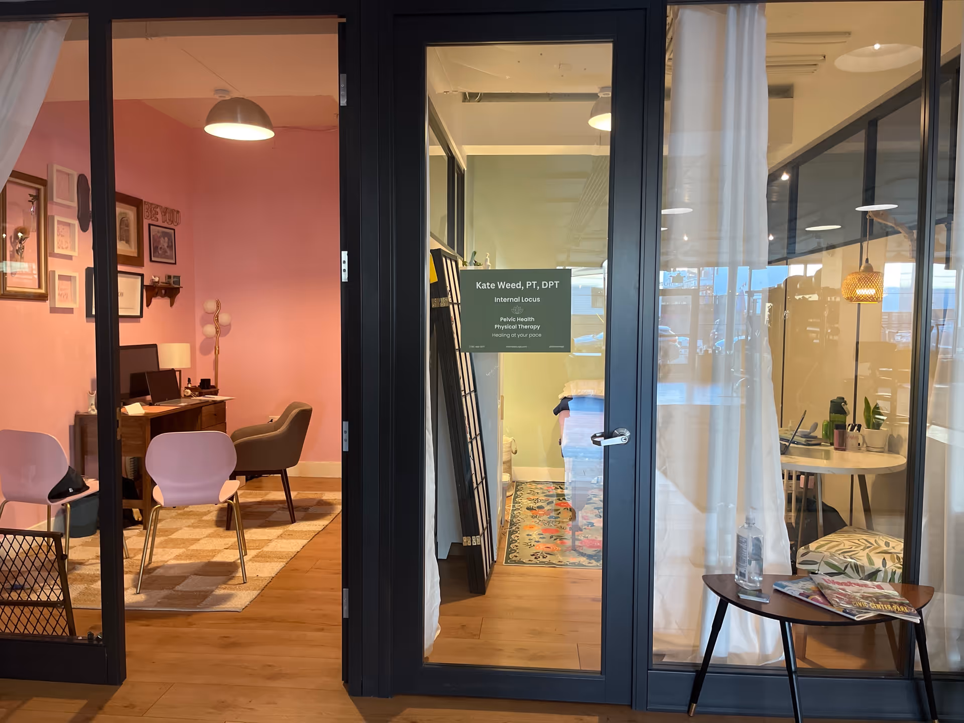 Bright interior of a pelvic health physical therapy facility with pink room, glass doors, and seating.