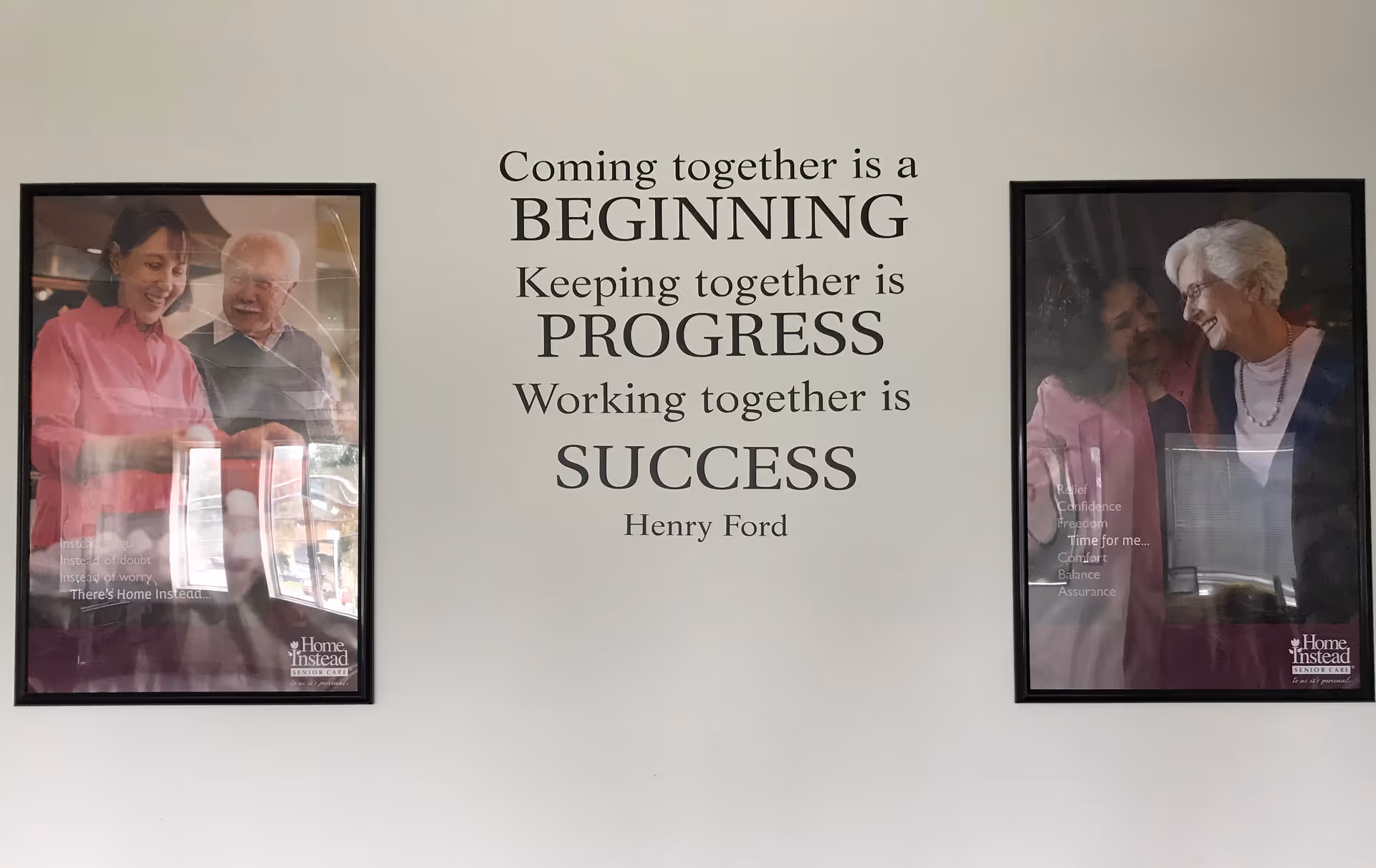Interior wall with a large centered quote between two framed photos of people
