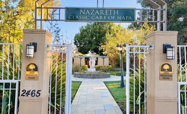 Entrance gate to Nazareth Classic Care of Napa with a stone path and fountain.