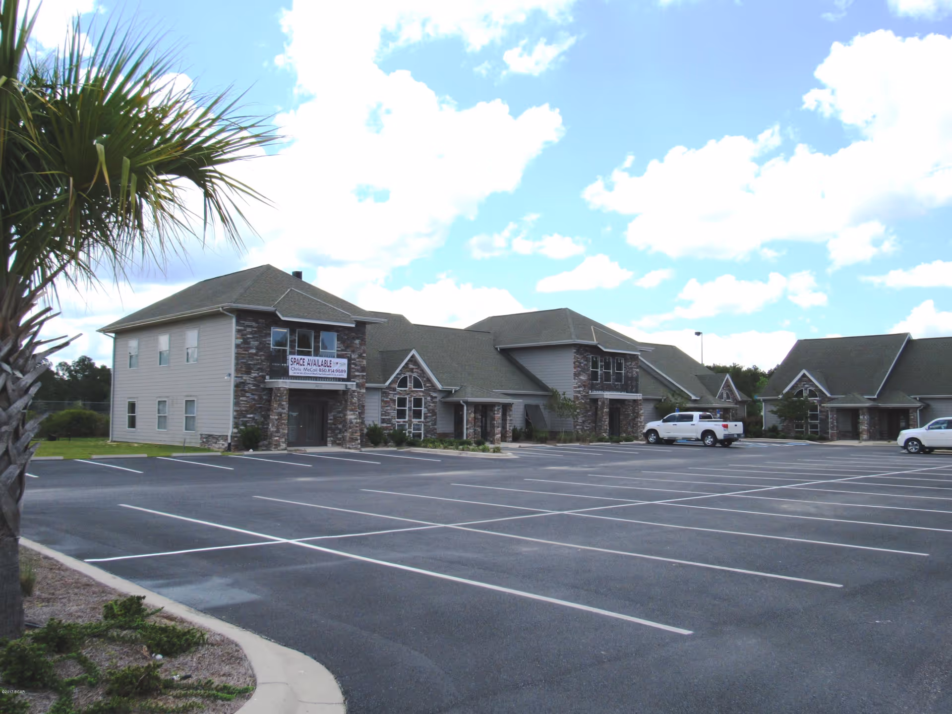 Exterior view of SunCrest Omni Home Health facility with a large parking lot.