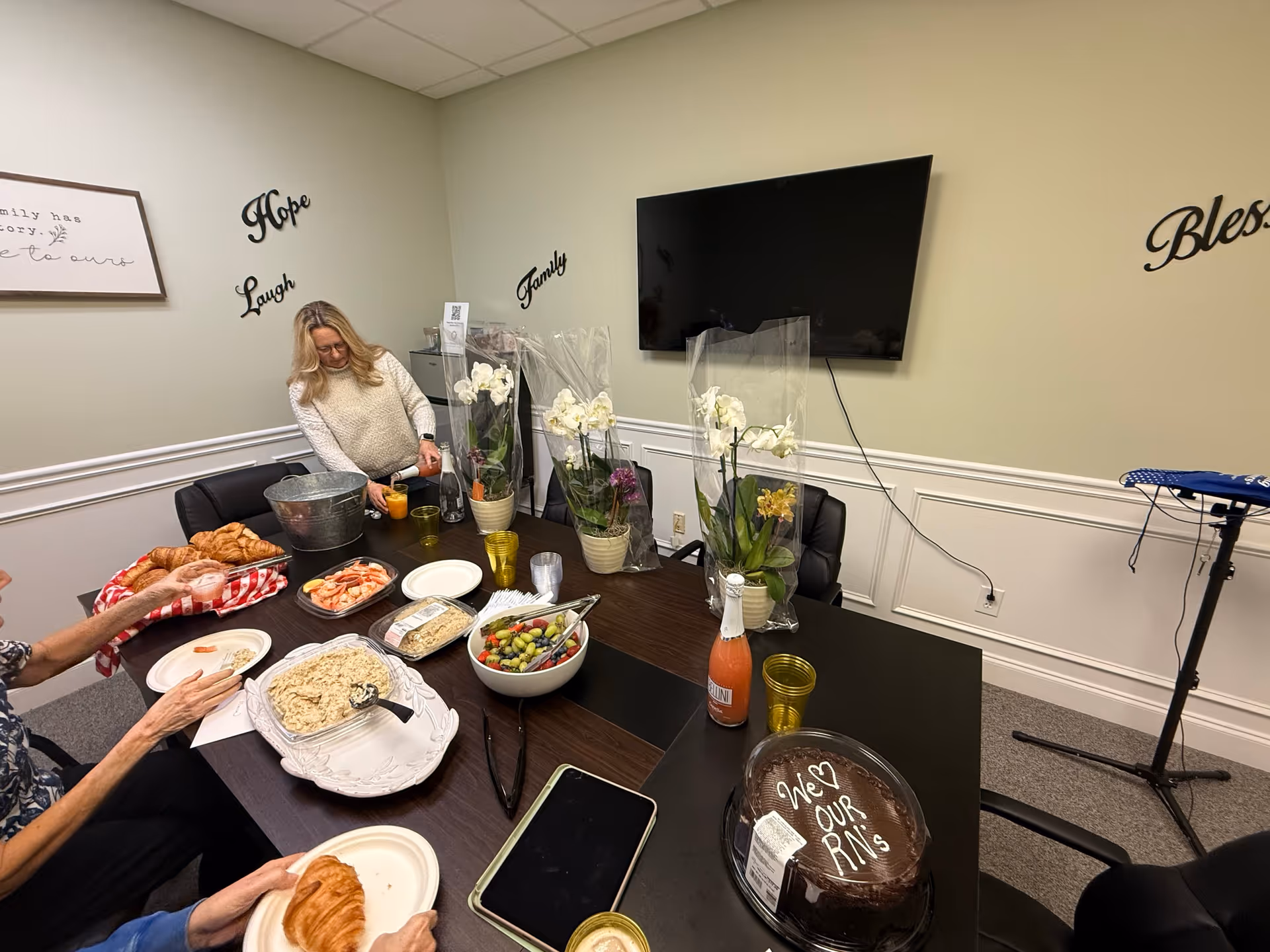 Dining room in a senior facility with a long table of food and residents.